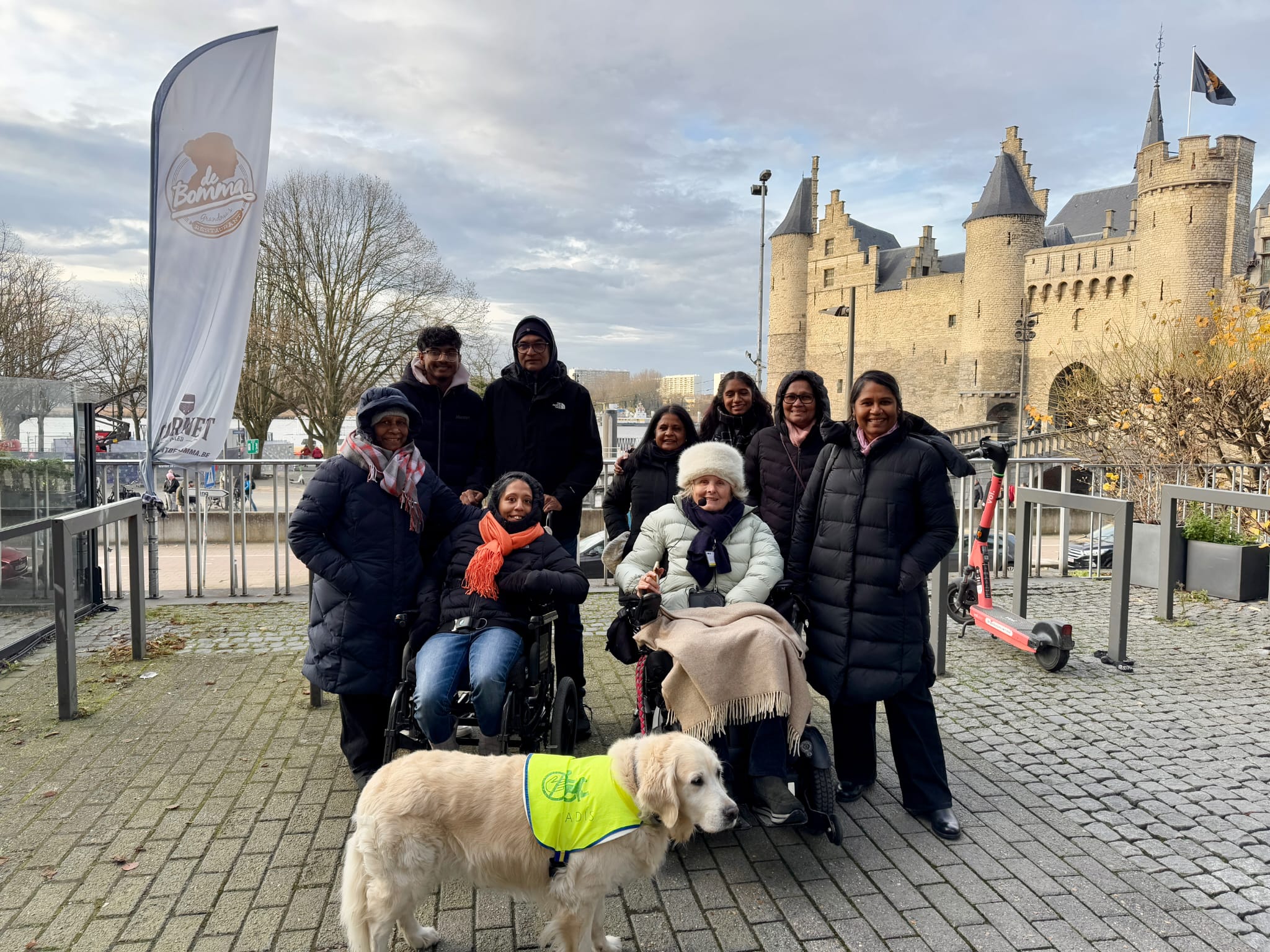 The walking tour of Antwerp was hosted by a guide in a wheelchair with an assistance dog. The family huddled together in a group hug. 